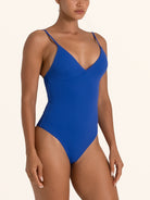 Side angle of blue textured V neck one piece swimsuit with high cut leg design.