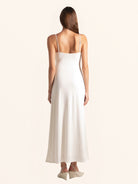 Rear full body view of white keyhole midi dress flowing hem