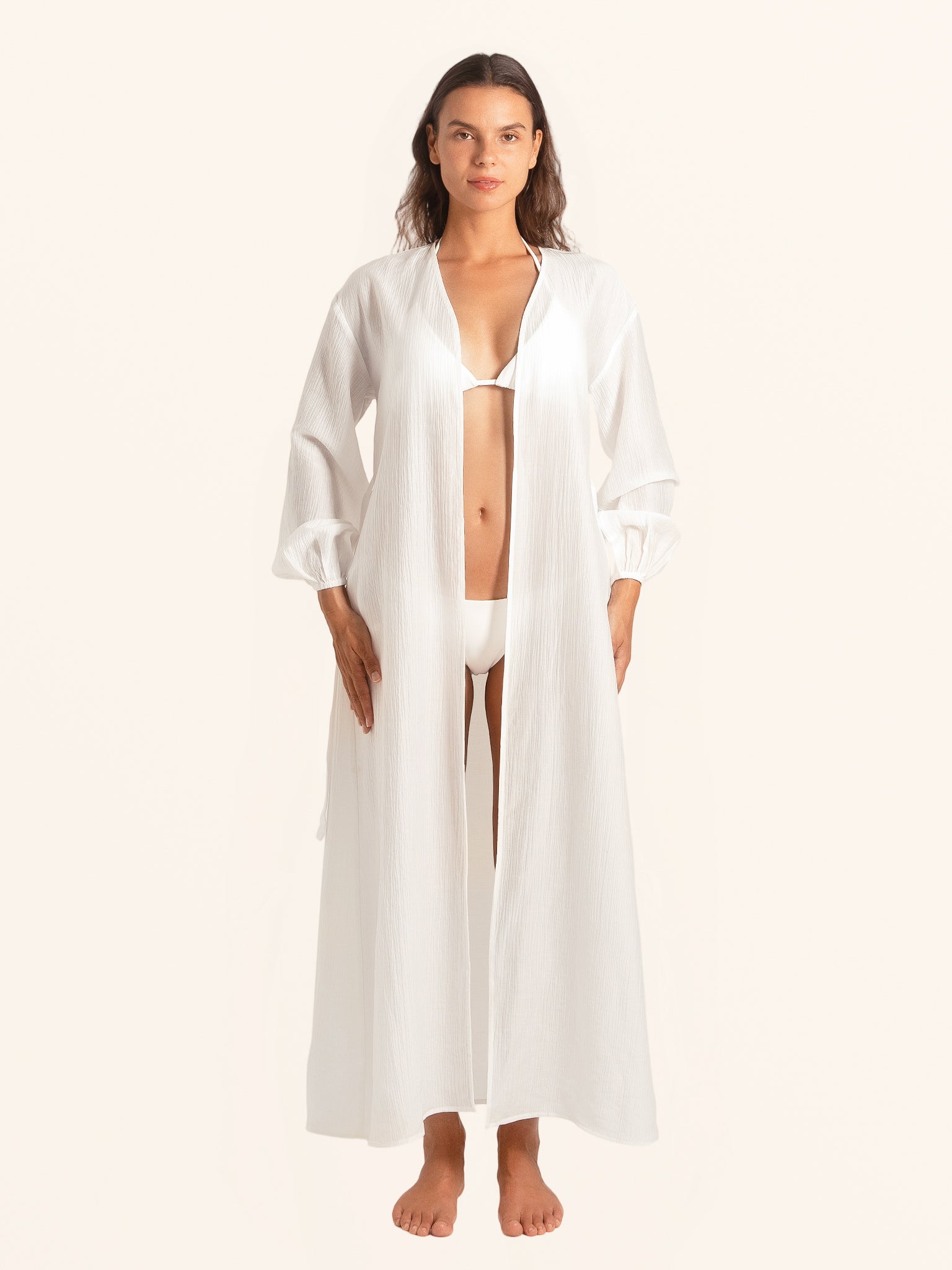 Front open style of white long sleeve maxi dress worn as beach cover up
