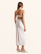 Back view of white midi dress with thin straps and cut out