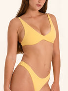 Mustard yellow swimwear top with a modern cut and adjustable back clasp.