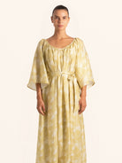 Front view of mustard yellow floral maxi dress with belted waist