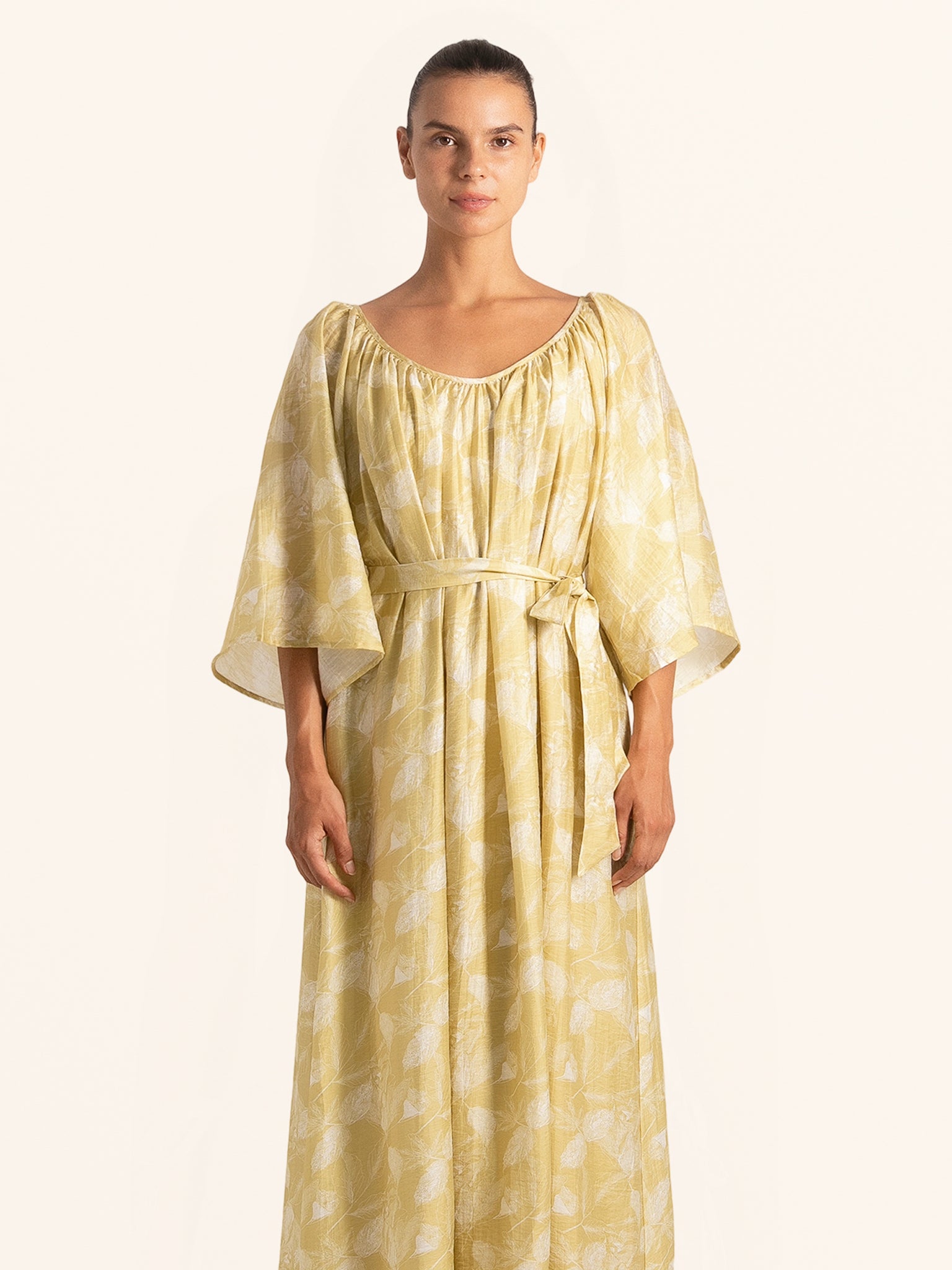Front view of mustard yellow floral maxi dress with belted waist