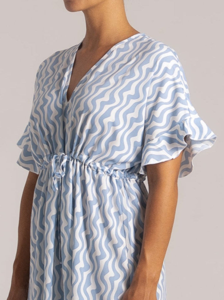 Ocean Mystery blue & white wave print maxi dress with V-neck and flutter sleeves - cinched waist summer dress with flowy silhouette.