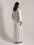 Ocean Mystery's textured white linen robe with loose sleeves and waist tie, styled for minimalist loungewear against neutral studio backdrop.