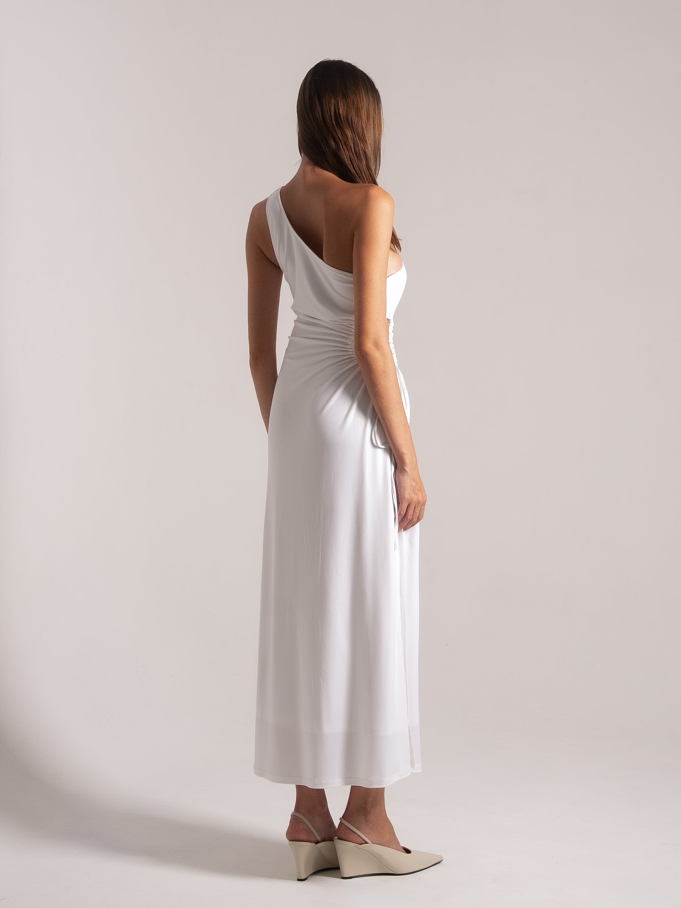 Ocean Mystery white one-shoulder maxi dress with draped waist - elegant back view with wedge heels.