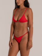 Angled front view of red string bikini with triangle top and low cut bottom