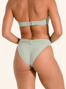 Minimalist bandeau bikini bottom in light green with smooth texture.