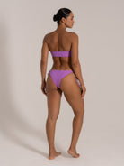 Back angled view of purple bandeau bikini with textured fabric