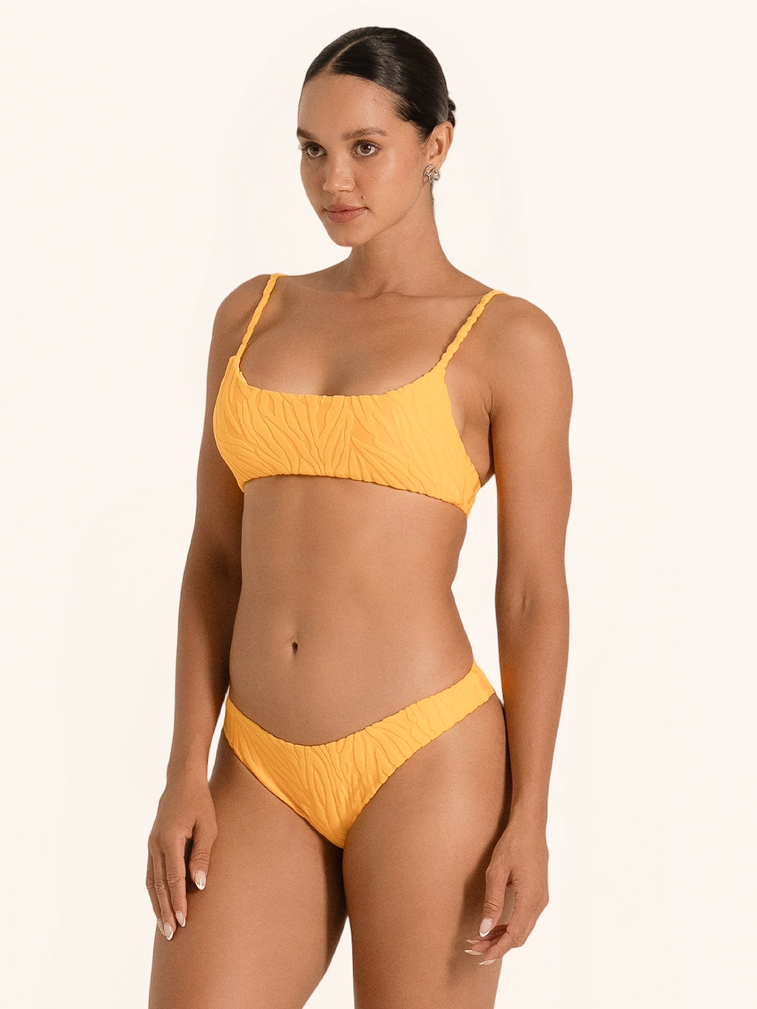 Back angle of mustard yellow bikini bottom showing cheeky fit and mid rise waist.