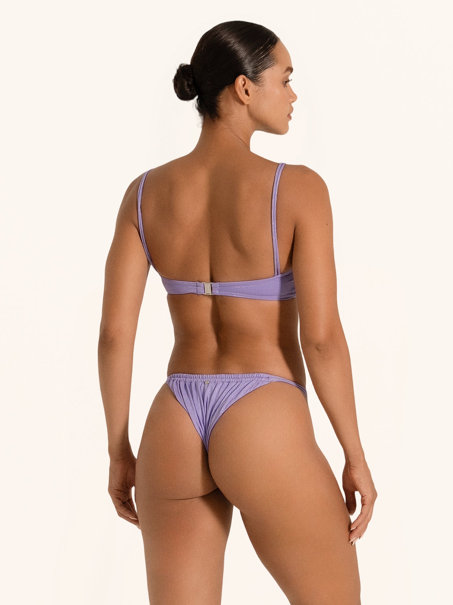 Back angle of purple bikini bottom with cheeky cut, styled with matching bandeau bikini top.
