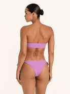 Side view of purple tie side bikini bottom with sleek fit and matching bandeau bikini top.