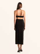 Rear full view of black deep V cut out dress with halter neckline
