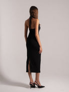 Side‑back view of black halter cutout midi dress with side slit