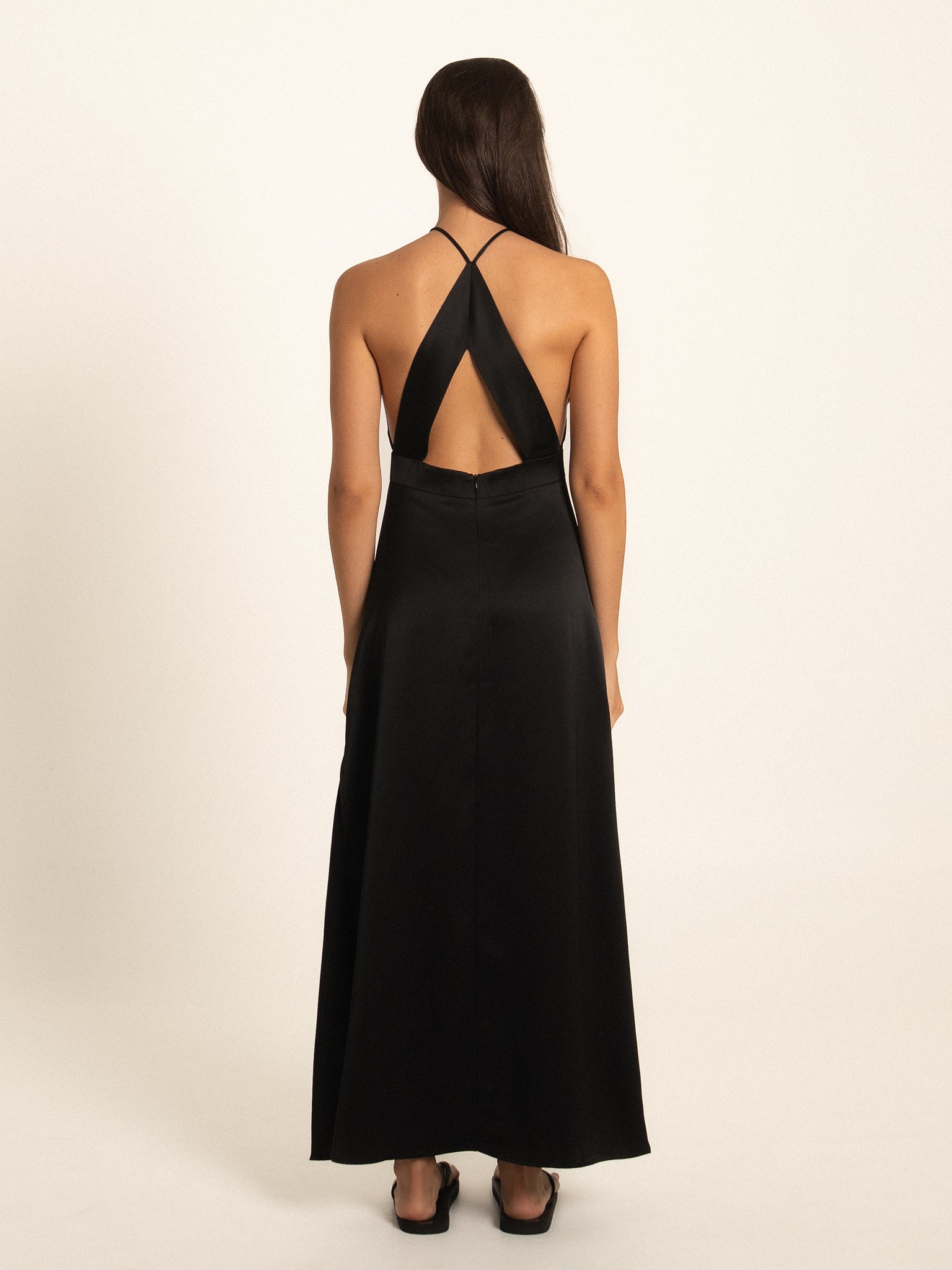 Rear full body view of black maxi dress with open back design