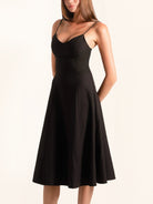 Side angle of black fit and flare midi dress with slim straps