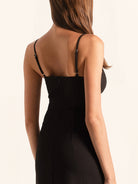 Back view of black spaghetti strap mini dress with fitted silhouette