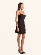 Full body side angle view of black mini dress with sweetheart neckline
