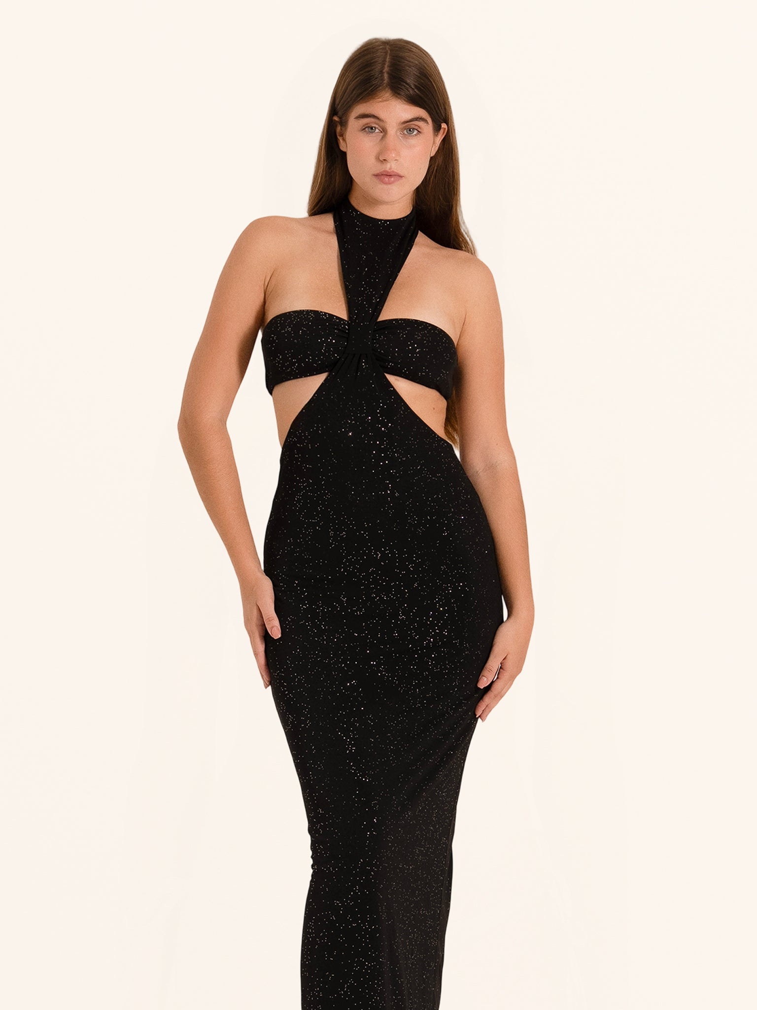 Front view of black sequined cut out halter neck evening dress