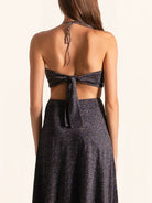 Back view of black sequined cut out maxi dress with halter tie straps