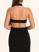 Back view of black halter evening dress with cut out waist design