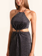 Closeup of black sequined maxi dress with halter neckline and cut out waist