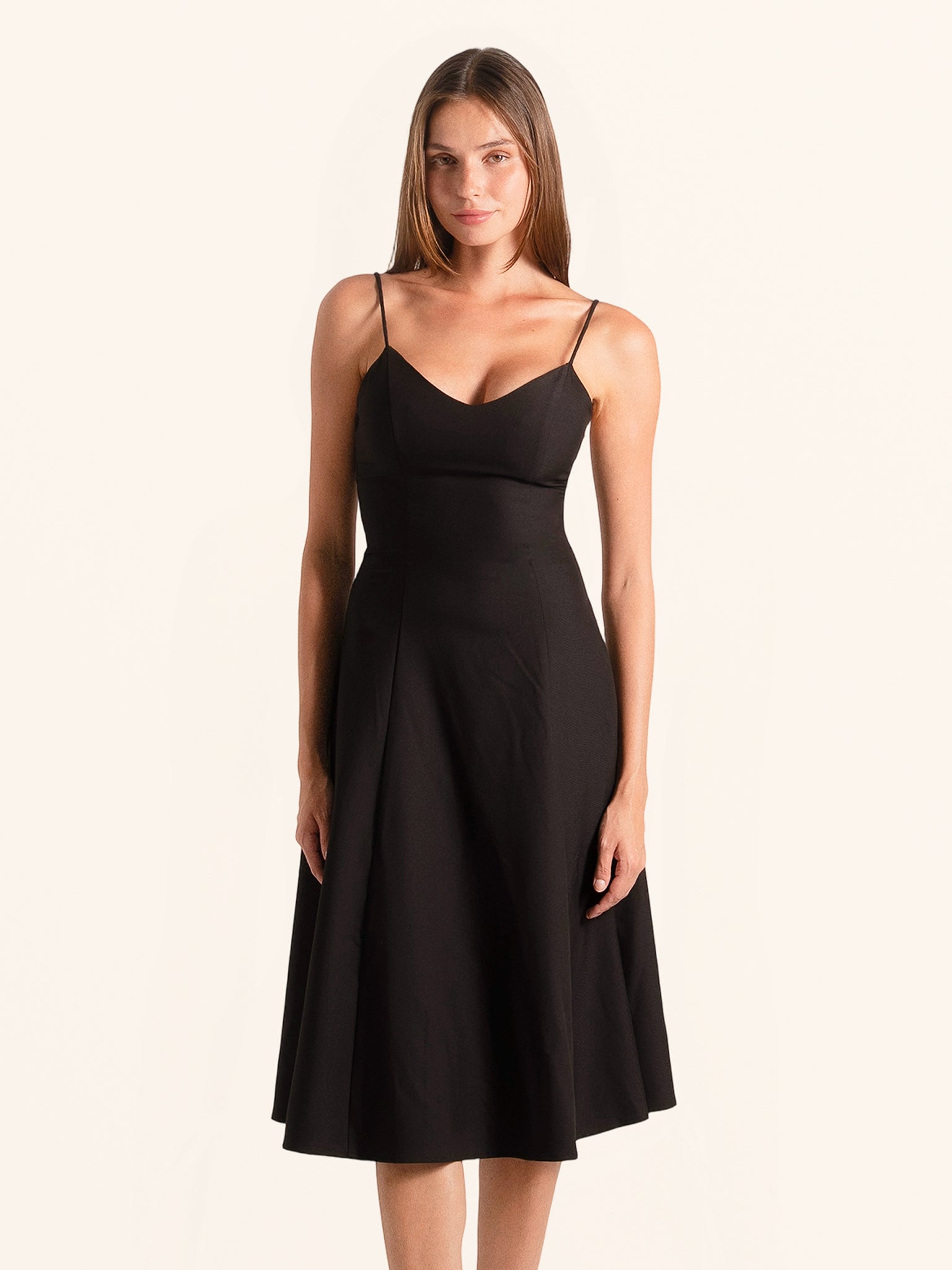 Front view of black spaghetti strap midi dress with flared hem
