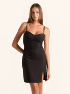 Front view of black spaghetti strap mini dress with front slit and sweetheart neckline