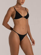 Close-up of a black triangle bikini with thin straps and soft textured fabric