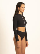Side profile view of the black long-sleeve rash guard, showcasing the streamlined, chafe-free fit that moves flawlessly with you during active water sports.
