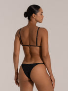 Back view of black textured triangle bikini top with thin adjustable straps