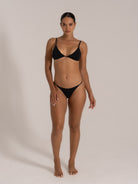 Front view of model wearing a black triangle bikini set with adjustable straps