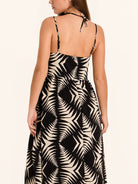 Back view of black and white leaf print midi dress with adjustable straps