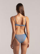 Back view of model wearing adjustable strap blue bikini set