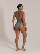 Model in a back-angle pose wearing a blue gradient tie-back bikini set with side tie bottoms.