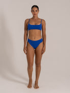  Front-facing model in royal blue ribbed bikini with square neck top and flattering high-cut waist.