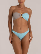 Front view of baby blue bikini bottom styled with resin rings on both sides for a modern beach look