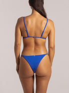 Back view of blue bikini bottom with minimal coverage and textured stretch fabric
