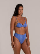 ide view of a woman in a stylish blue textured bikini set with thin straps and flattering high-waisted fit.