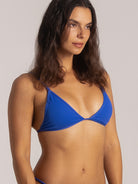 Side close-up of blue triangle bikini top showing flattering shape and soft textured fabric