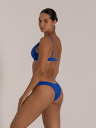 Back angle showing the clasp closure and medium-coverage bottoms of the textured blue bikini set.