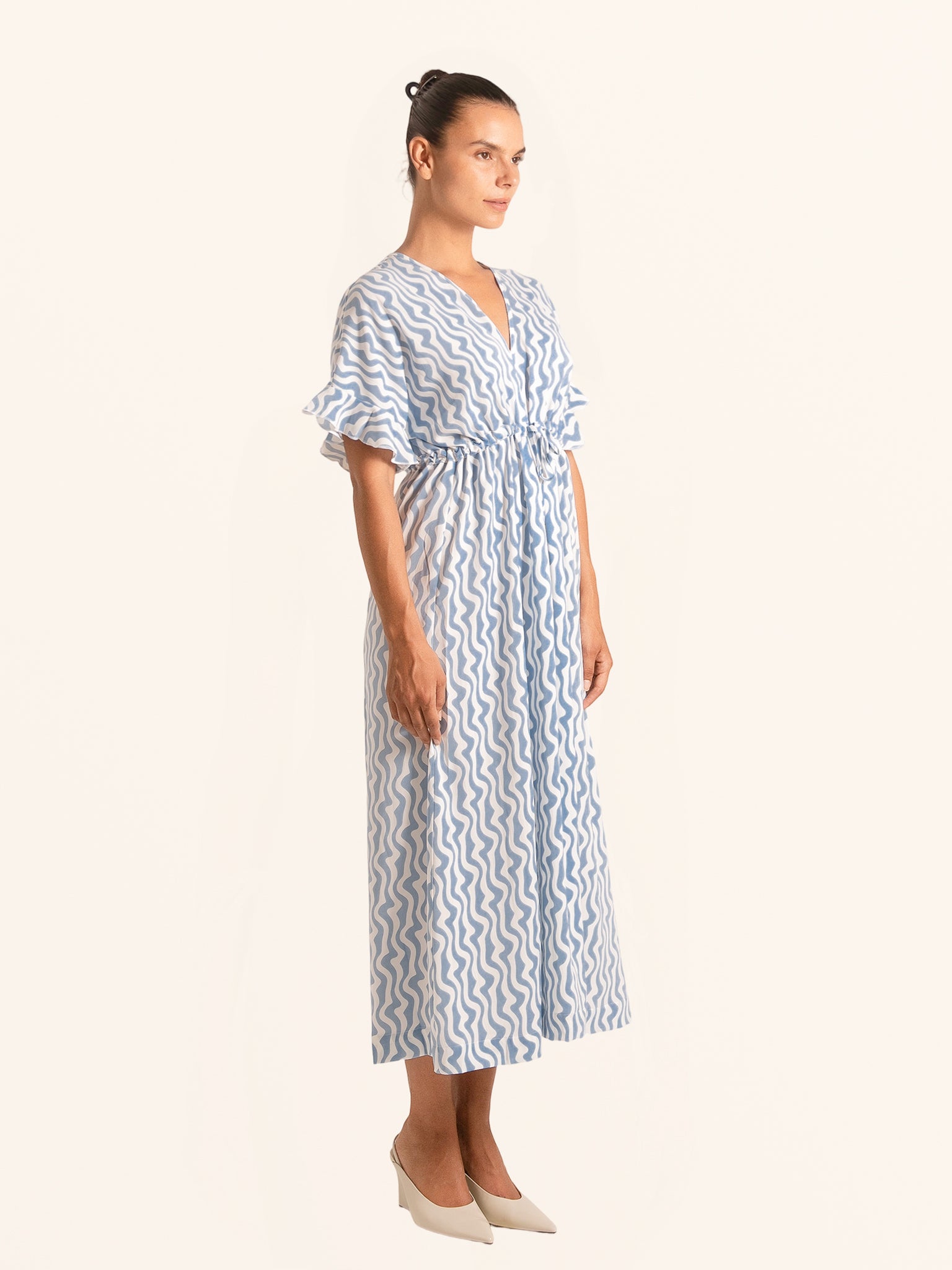 Side view of blue and white printed maxi dress with flutter sleeves