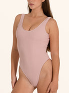 Blush pink ribbed one piece swimsuit with low back design.