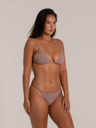 Model showcasing a textured brown triangle bikini set with delicate straps, ideal for modern beachwear looks.
