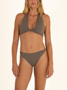Close-up front view of a woman modeling the charcoal gray twist halter bikini top and matching bottoms, highlighting the fabric texture and twist details.