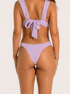 Side angle of purple textured V-shape bikini bottom offering flattering high rise fit.