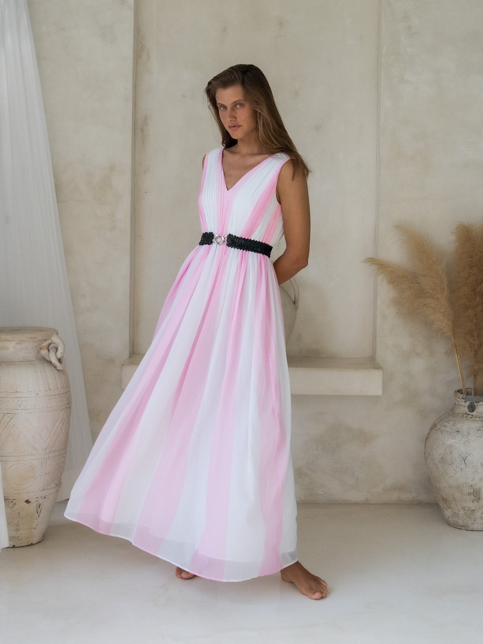 Fashion-forward V-neck white and pink pleated long dress paired with a sparkling black sequin belt.