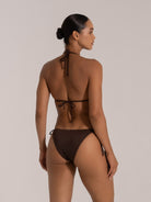 Woman wearing a chocolate brown string bikini, showing the back view with tie-up details.