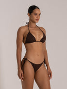 Stylish chocolate bikini with triangle top and adjustable strings, side view of model.