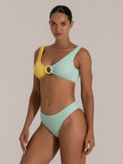 Angled front view of a mint and yellow ring bikini top in textured fabric